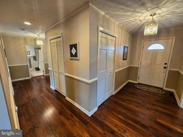 a bedroom with a bed chair and two windows