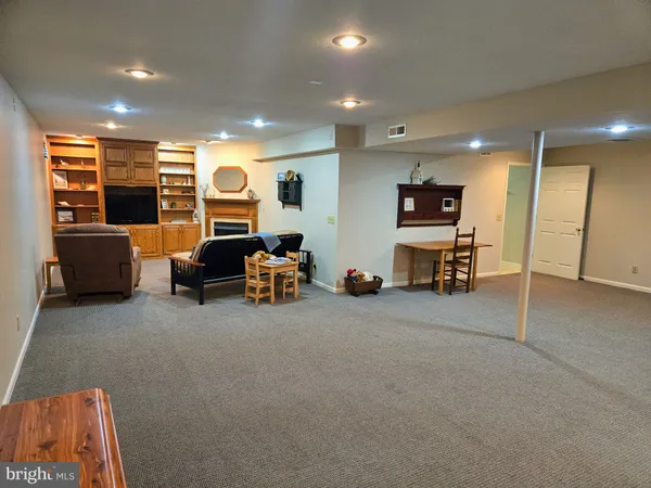 a kitchen with stainless steel appliances granite countertop a stove a sink a refrigerator a microwave a dining table and chairs with wooden floor
