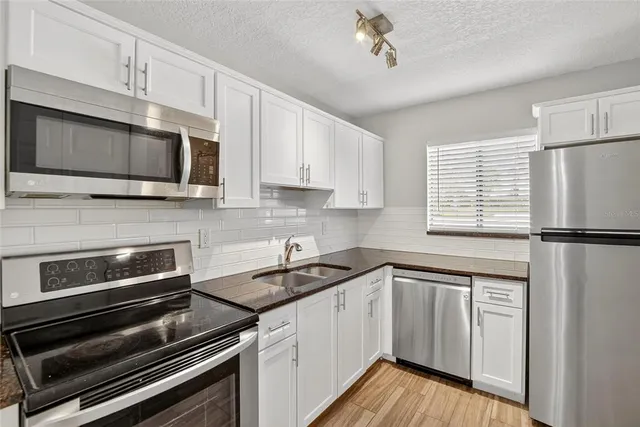 a kitchen with cabinets appliances and a window