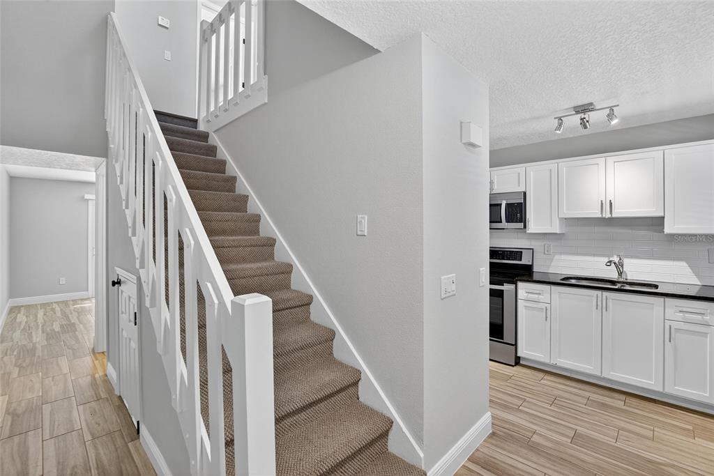 4415 Dylan Loop, Unit 179 Land O' Lakes, FL 34639 - Photo 14 of 50 a kitchen with granite countertop white cabinets and white appliances