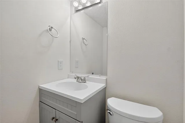 a bathroom with a sink a toilet and vanity