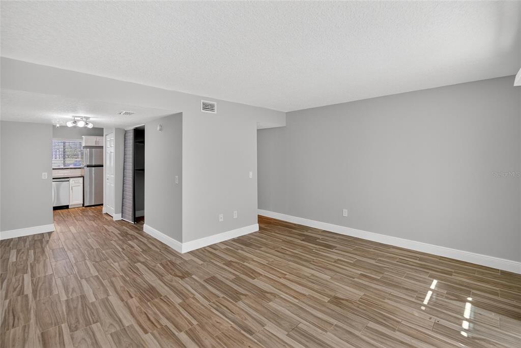 4415 Dylan Loop, Unit 179 Land O' Lakes, FL 34639 - Photo 24 of 50 a view of empty room with wooden floor and kitchen