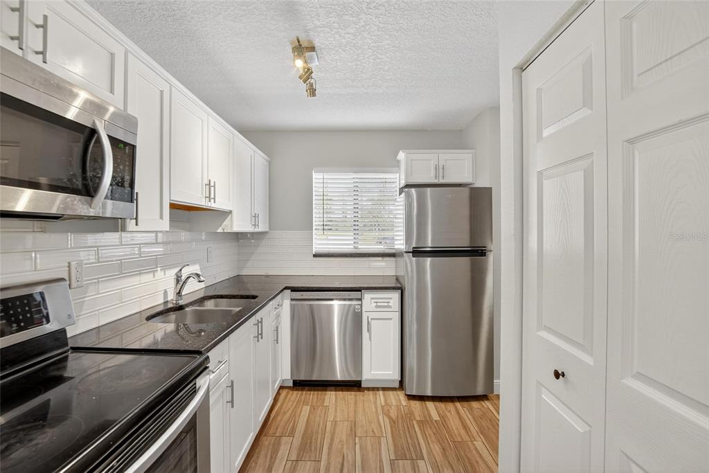 4415 Dylan Loop, Unit 179 Land O' Lakes, FL 34639 - Photo 7 of 50 a kitchen with stainless steel appliances granite countertop a refrigerator sink and microwave