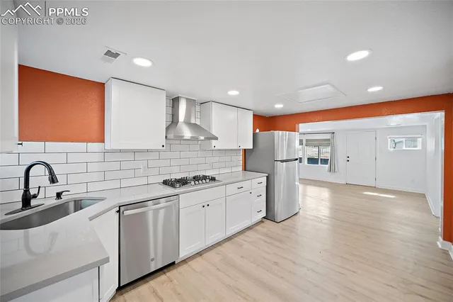 a kitchen with white cabinets and white stainless steel appliances