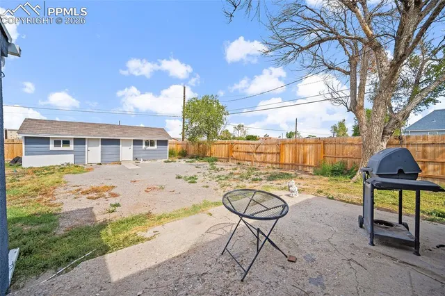 a view of an house with backyard and tree
