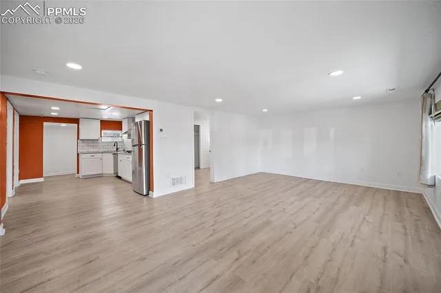 a view of an empty room with wooden floor