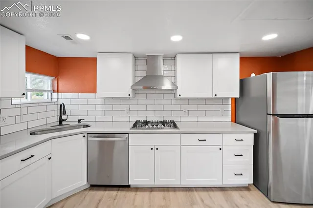 a large kitchen with stainless steel appliances granite countertop a lot of counter space and wooden floors