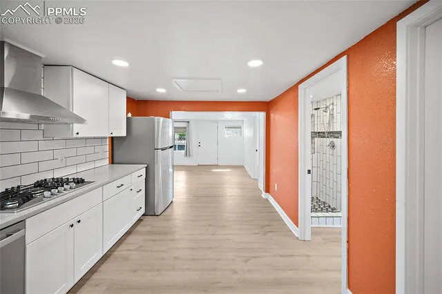 a kitchen with white cabinets and sink