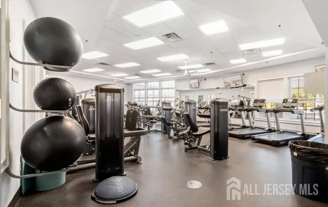 a room with gym equipment and lots of windows