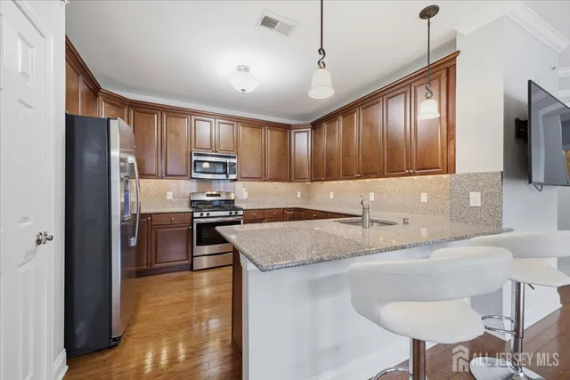 a kitchen with stainless steel appliances granite countertop a sink refrigerator and cabinets