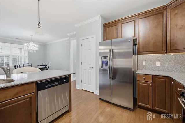 a kitchen with kitchen island granite countertop a sink and refrigerator