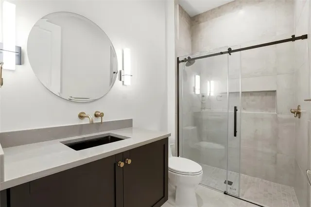 a bathroom with a sink a toilet and a mirror