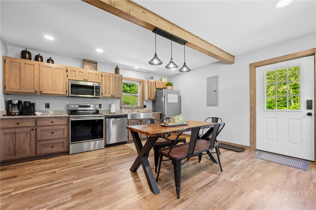 634-636 Watauga River Road Sugar Grove, NC 28679 - Photo 38 of 50 a kitchen with stainless steel appliances kitchen island granite countertop a stove top oven a sink a dining table and chairs with wooden floor