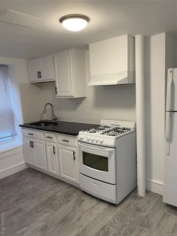 a kitchen with granite countertop white cabinets and white appliances