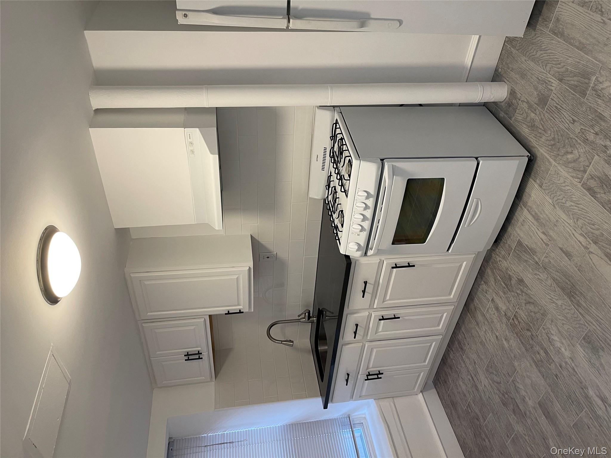 5783 Mosholu Avenue Bronx, NY 10471 - Photo 13 of 17 a kitchen with granite countertop white cabinets and white appliances
