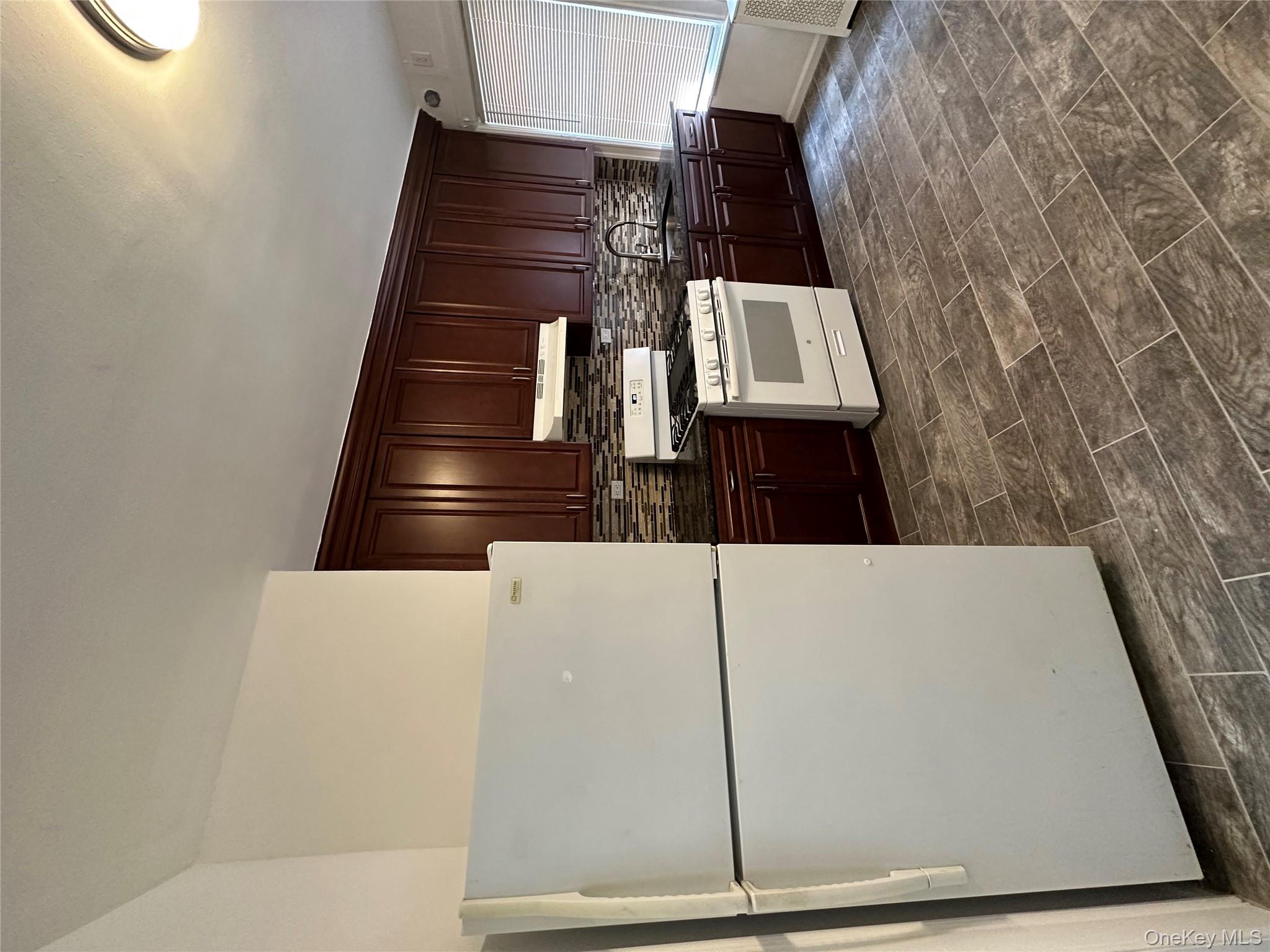 5783 Mosholu Avenue Bronx, NY 10471 - Photo 2 of 17 a white refrigerator freezer a stove sitting inside of a kitchen