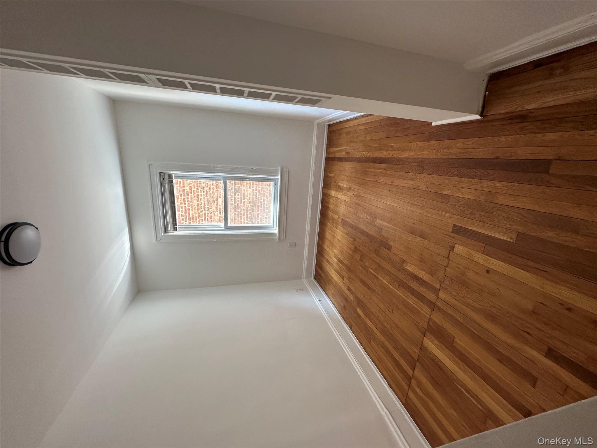 5783 Mosholu Avenue Bronx, NY 10471 - Photo 3 of 17 an empty room with wooden floor and windows