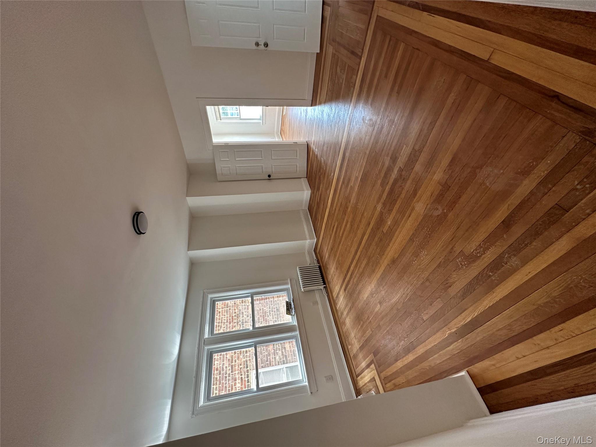 5783 Mosholu Avenue Bronx, NY 10471 - Photo 6 of 17 wooden floor in an empty room with a window