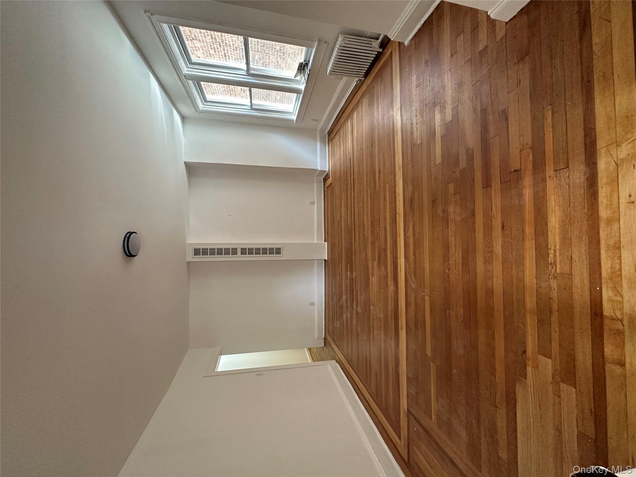 5783 Mosholu Avenue Bronx, NY 10471 - Photo 8 of 17 a view of an empty room with wooden floor and a window