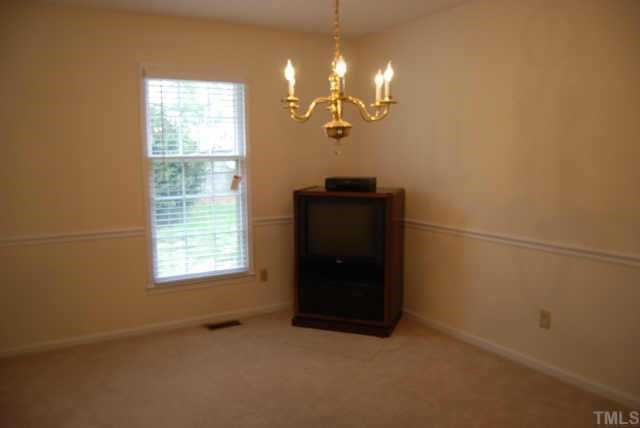 7408 Player Court Raleigh, NC 27615 - Photo 3 of 12 An elegant dining room welcomes with Step up floor, neutral carpet, neutral wall paint, painted chairrail, chandelier, single window with 2 blinds. It will be a pleasure to entertain here Other