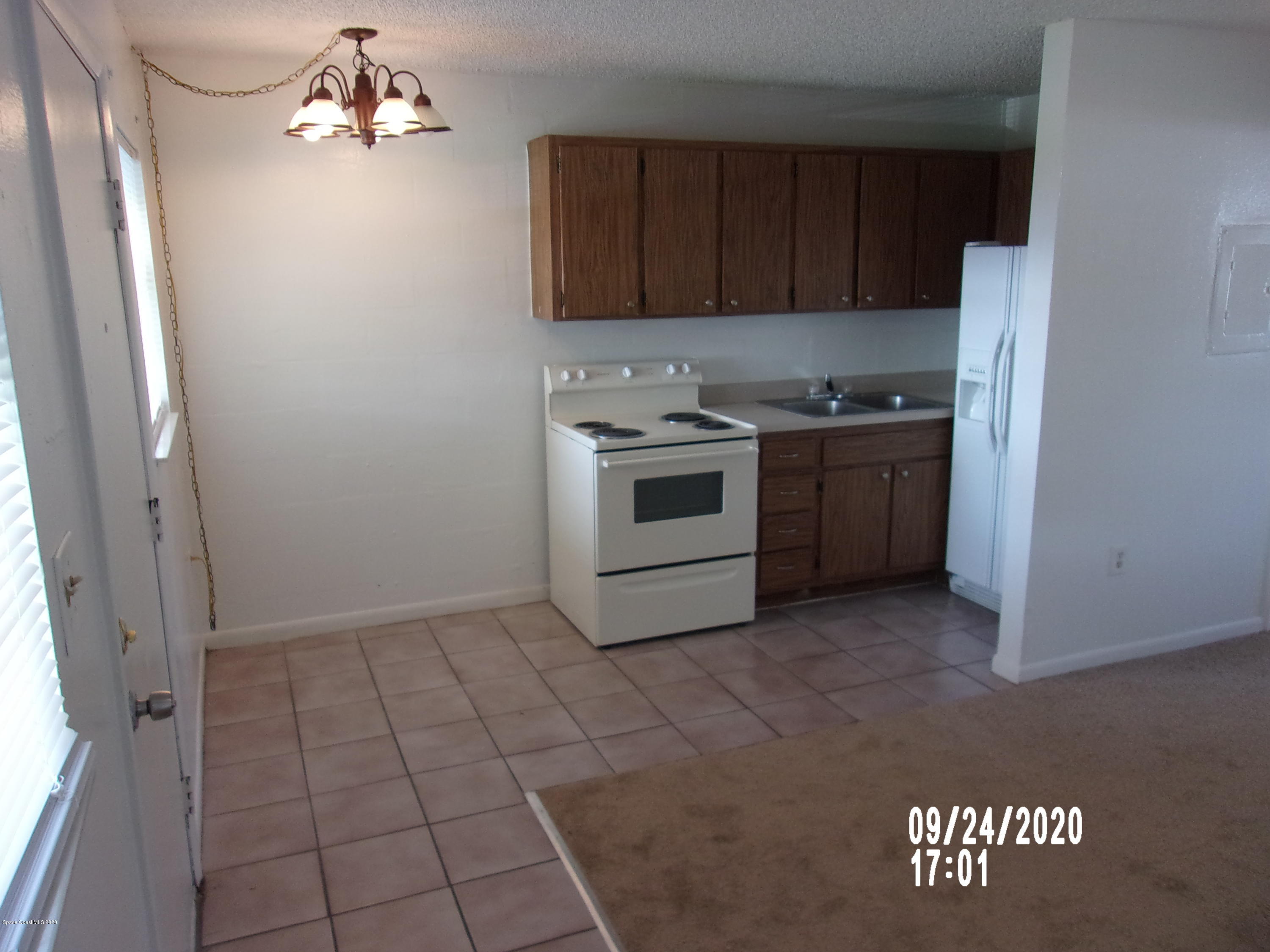 1713 Dixon Boulevard, Unit 156 Cocoa, FL 32922 - Photo 2 of 12 a kitchen with granite countertop a stove a sink and a refrigerator with wooden floor
