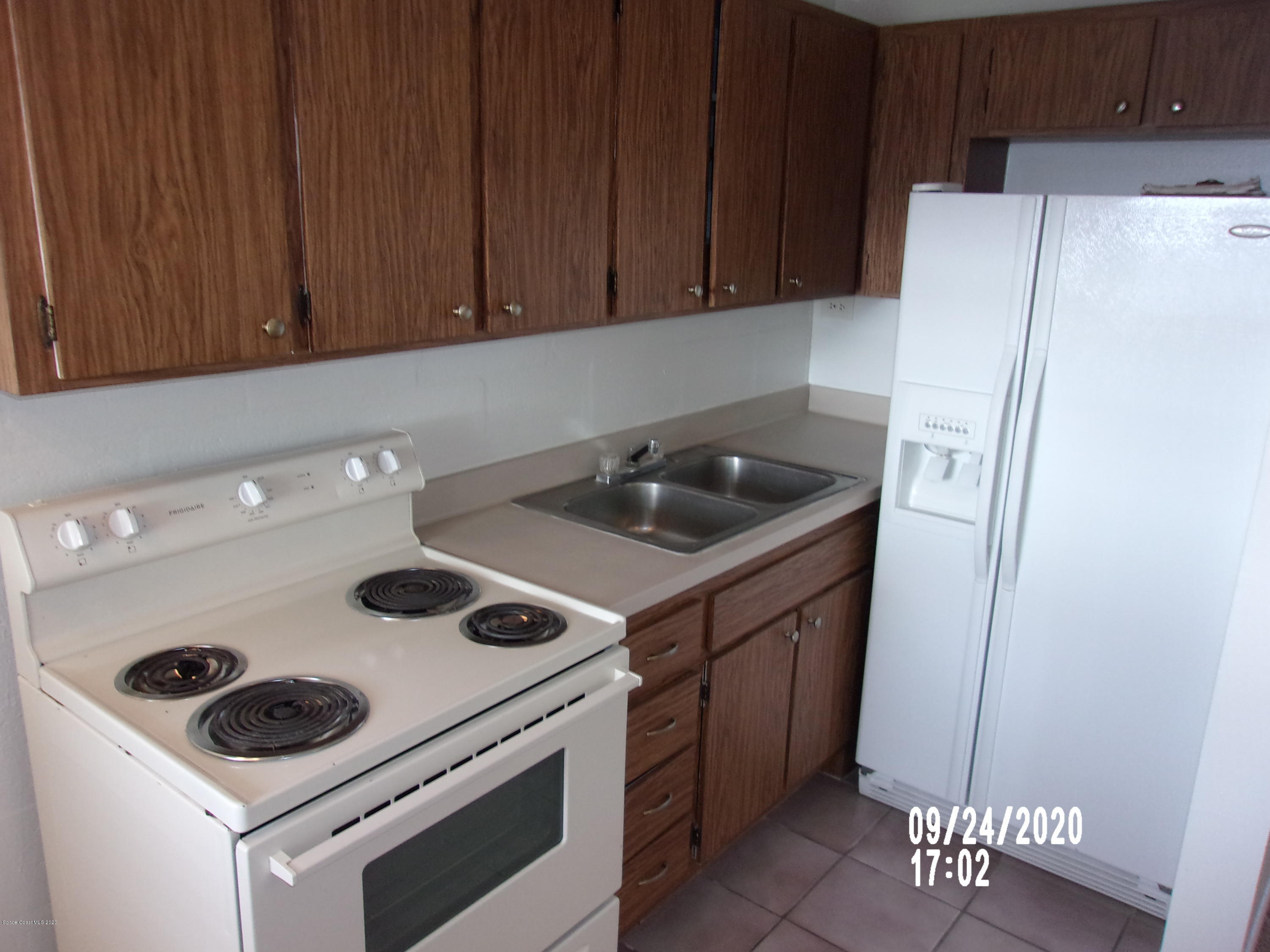 1713 Dixon Boulevard, Unit 156 Cocoa, FL 32922 - Photo 5 of 12 a kitchen with a refrigerator and a stove