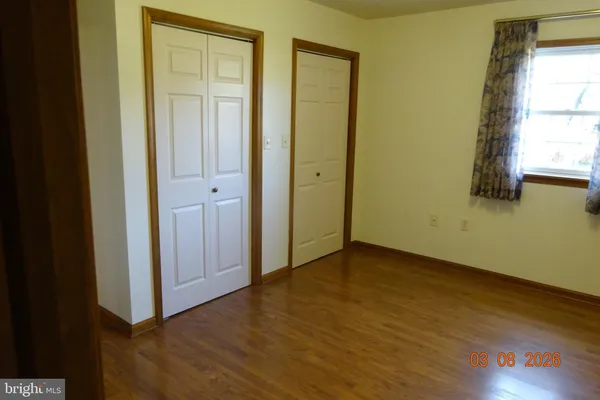 a view of a room with wooden floor and brick walls