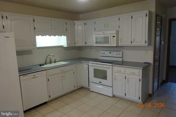 a kitchen with white cabinets stainless steel appliances and sink