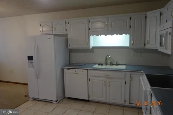 a kitchen with cabinets appliances a sink and a window
