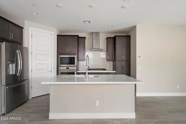 a kitchen with kitchen island a sink stove and refrigerator
