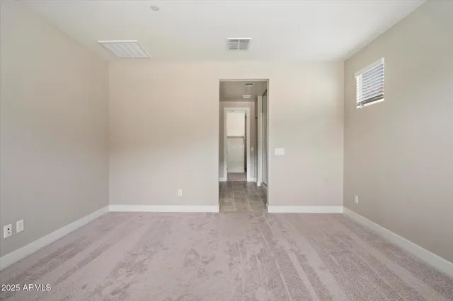 a view of an empty room with wooden floor and closet