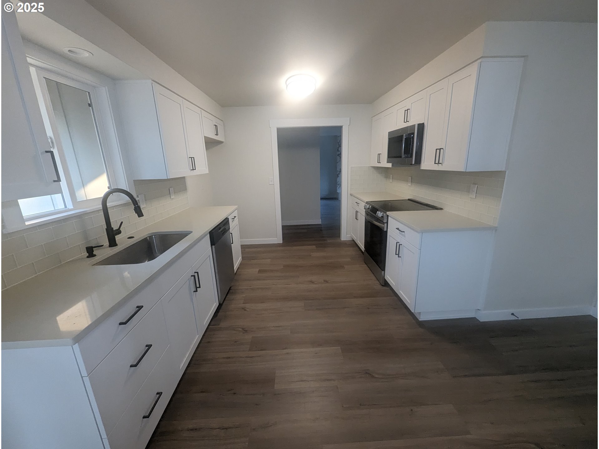 8009 Southwest Mapleleaf Street Portland, OR 97223 - Photo 8 of 16 a large kitchen with stainless steel appliances sink a microwave and cabinets