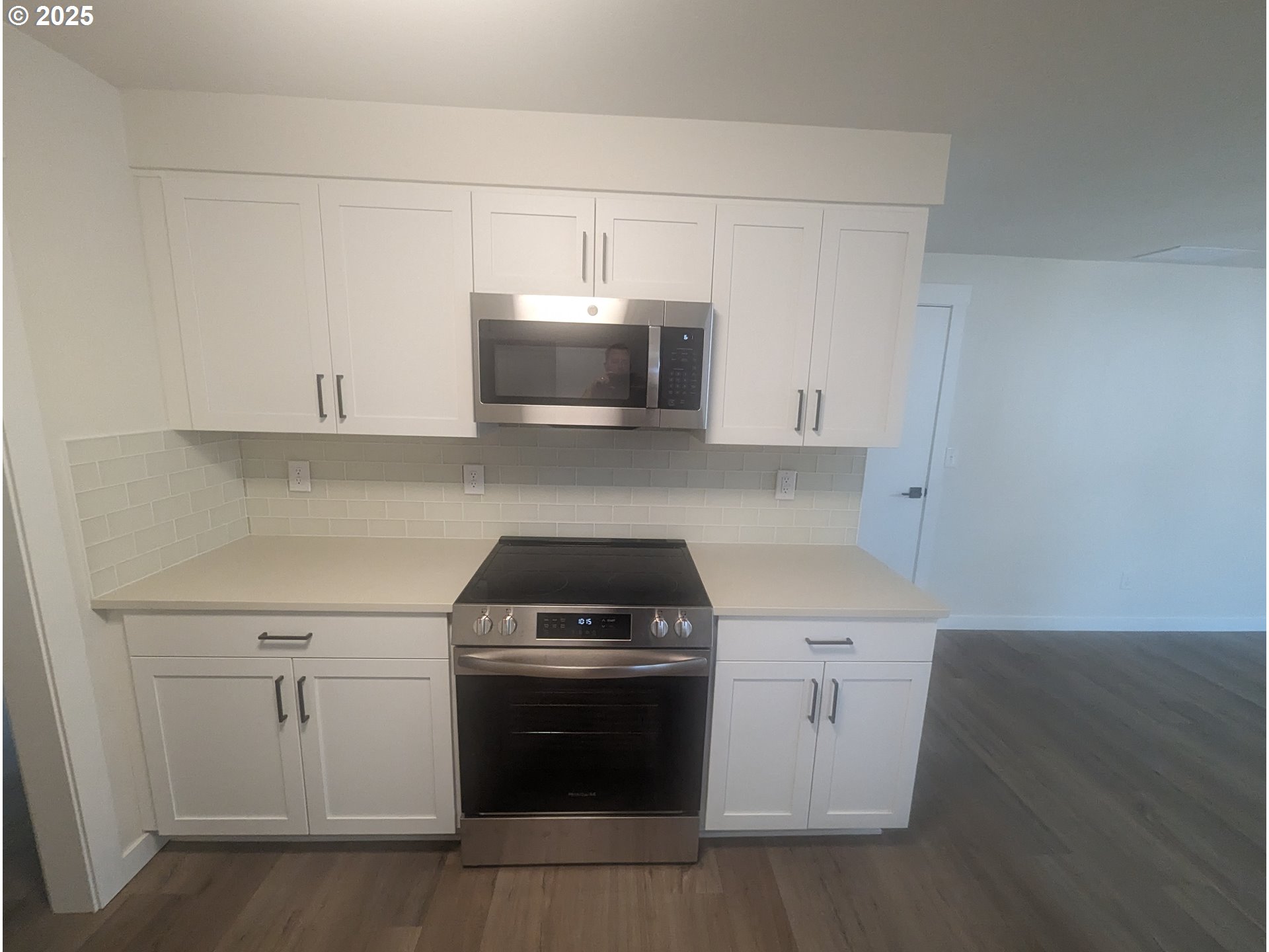 8009 Southwest Mapleleaf Street Portland, OR 97223 - Photo 9 of 16 a kitchen with white cabinets and stainless steel appliances