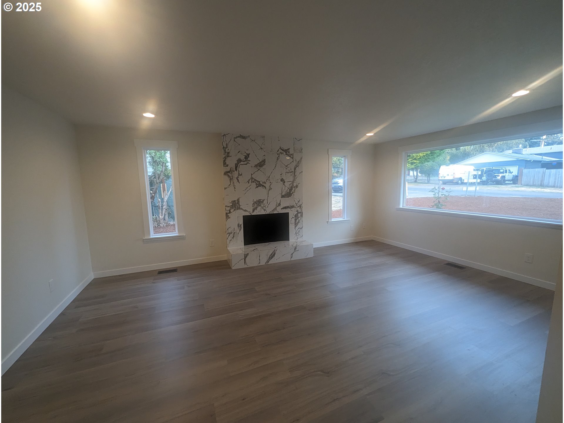8009 Southwest Mapleleaf Street Portland, OR 97223 - Photo 10 of 16 an empty room with wooden floor and windows