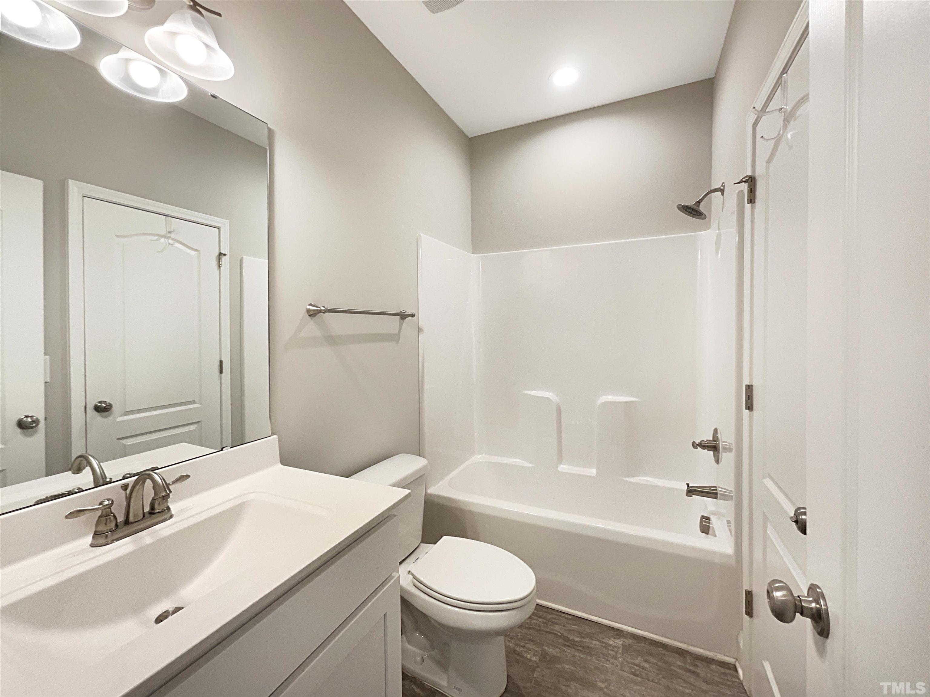 295 Edgefield Street Clayton, NC 27520 - Photo 11 of 21 a bathroom with a sink a toilet and shower
