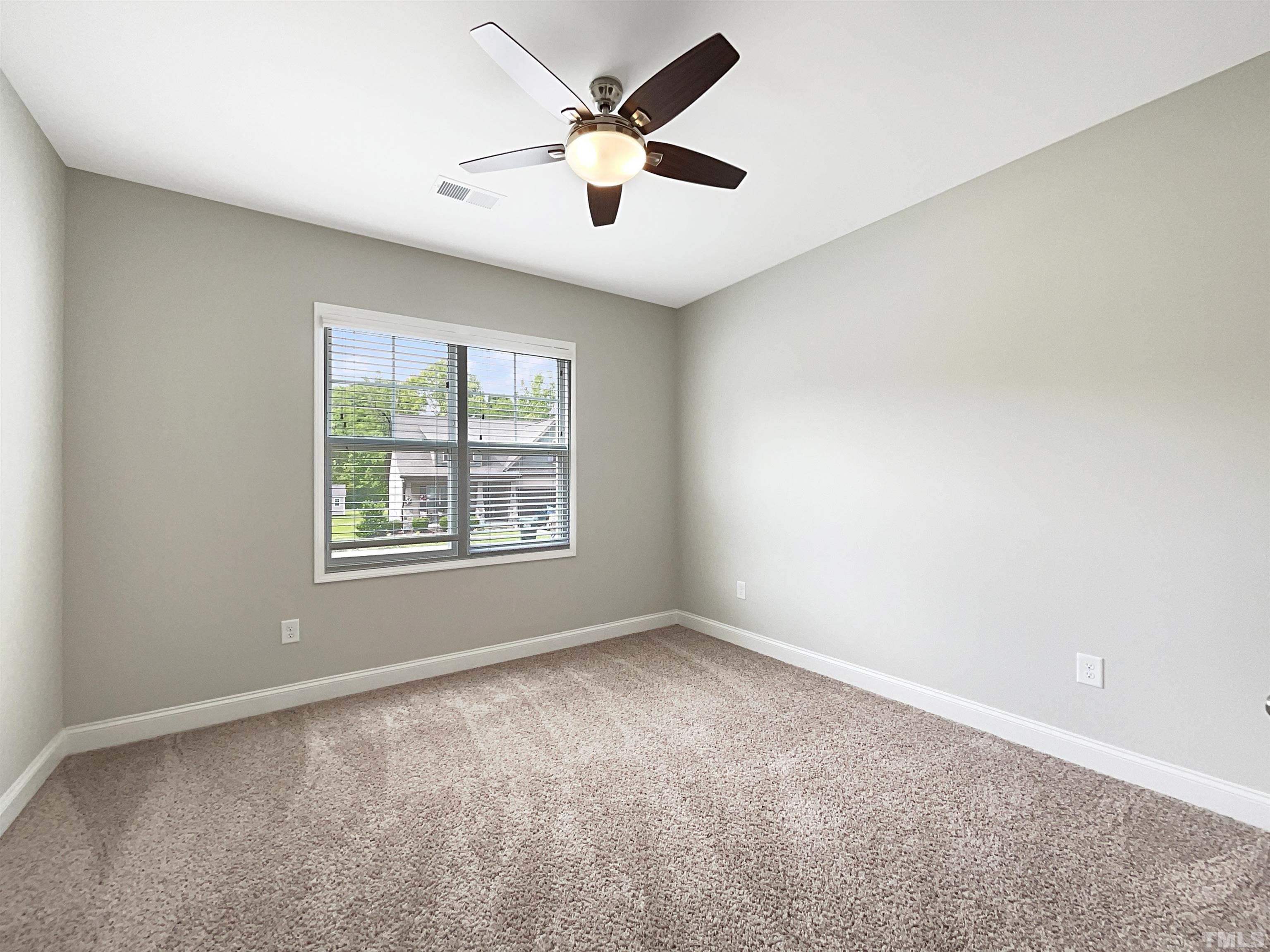 295 Edgefield Street Clayton, NC 27520 - Photo 13 of 21 an empty room with windows and ceiling fan