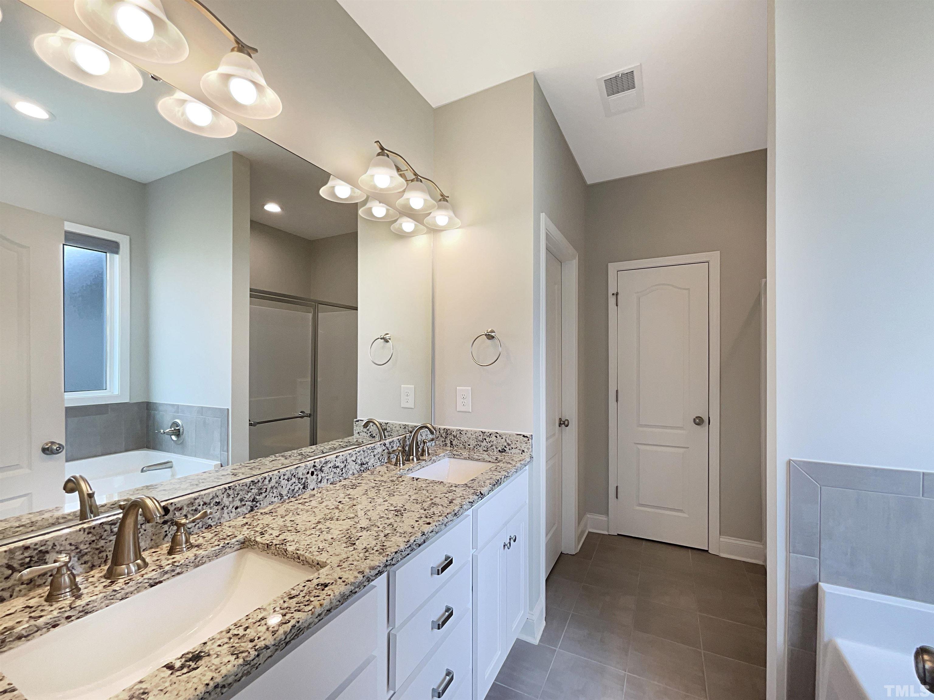 295 Edgefield Street Clayton, NC 27520 - Photo 17 of 21 a bathroom with a granite countertop double vanity sink and a mirror
