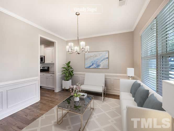 295 Edgefield Street Clayton, NC 27520 - Photo 2 of 21 a living room with furniture a chandelier and a table