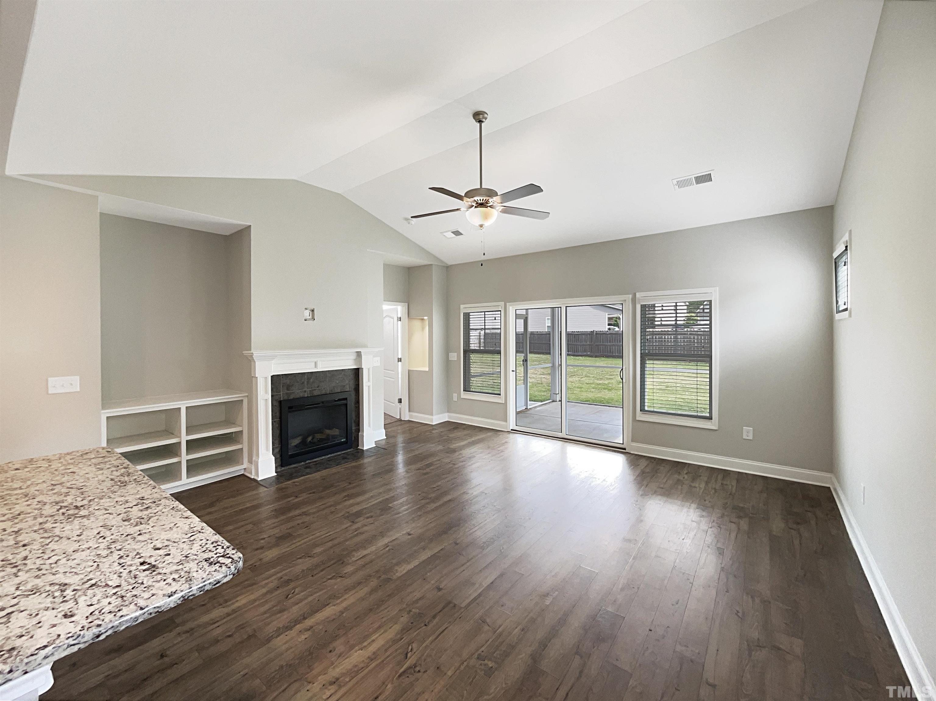 295 Edgefield Street Clayton, NC 27520 - Photo 5 of 21 a view of a livingroom with wooden floor a fireplace and windows