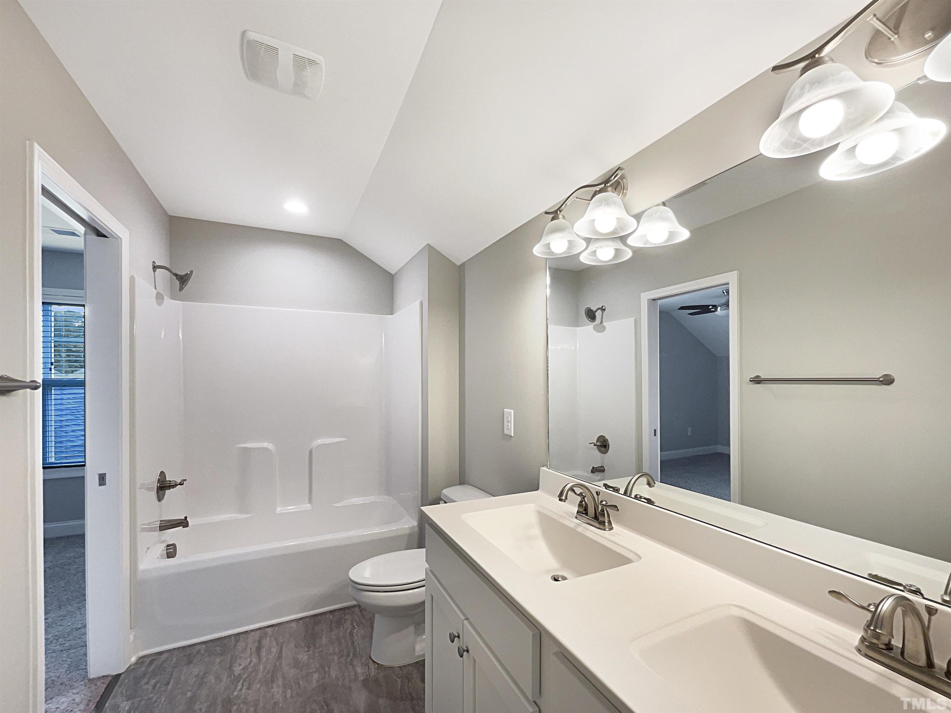 295 Edgefield Street Clayton, NC 27520 - Photo 6 of 21 a bathroom with a sink a toilet a large mirror and shower