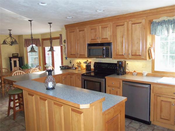 10 Adams Road Townsend, MA 01469 - Photo 8 of 30 a kitchen with a stove a sink a microwave a dining table and chairs