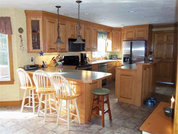 10 Adams Road Townsend, MA 01469 - Photo 9 of 30 a kitchen with stainless steel appliances kitchen island granite countertop a table chairs and a refrigerator