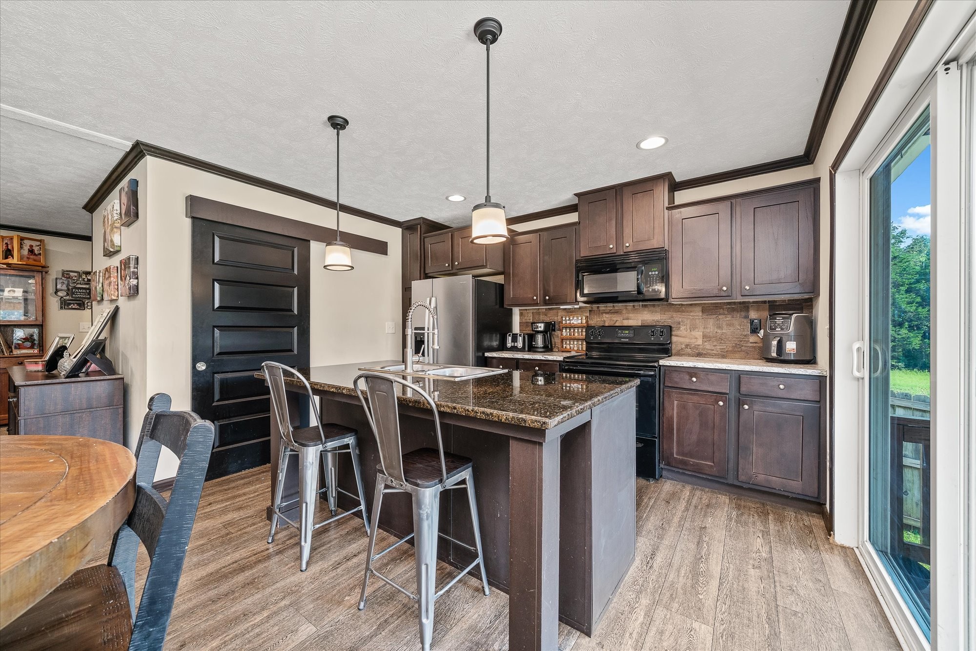 330 Griffintown Road Sparta, TN 38583 - Photo 17 of 43 a kitchen with stainless steel appliances granite countertop a stove top oven a sink dishwasher a dining table and chairs with wooden floor