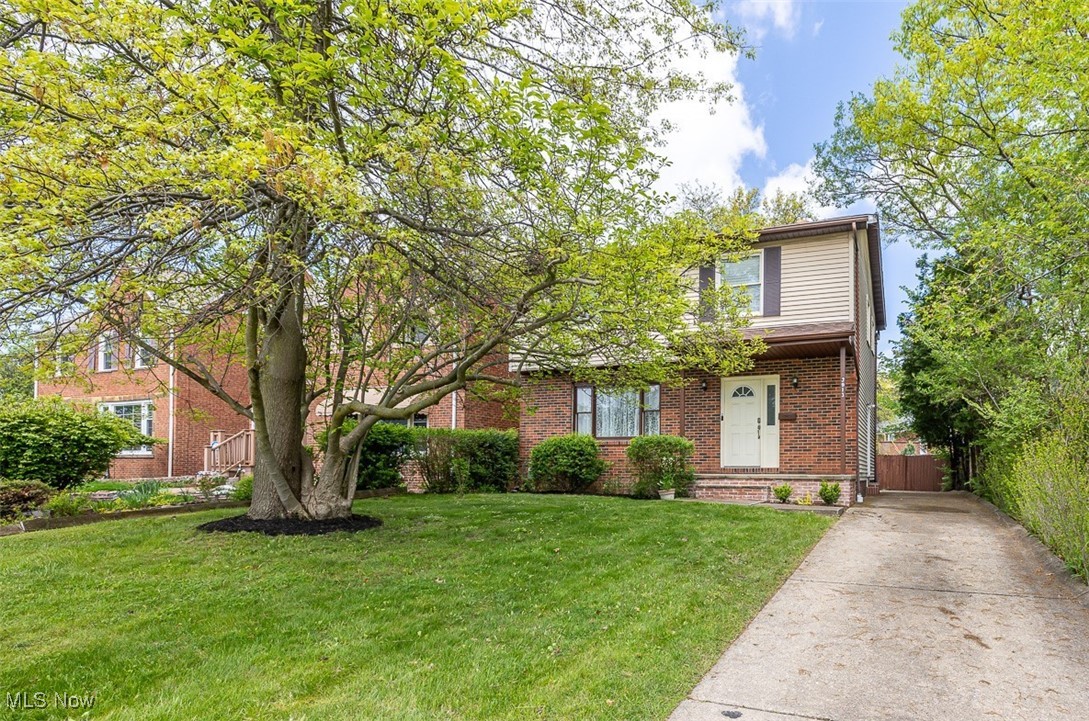 3913 Silsby Road Cleveland, OH 44118 - Photo 1 of 26 View of property hidden behind natural elements with brick siding, concrete driveway, and a front yard