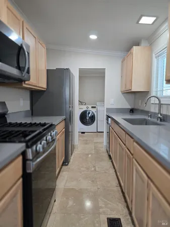 a kitchen with stainless steel appliances granite countertop a sink a stove and a refrigerator