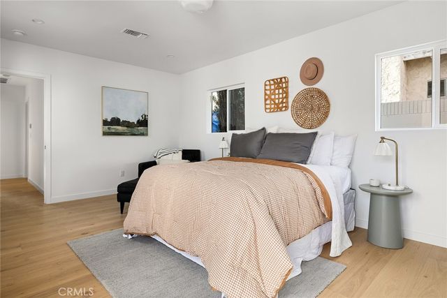 a bedroom with a bed and painting on the wall