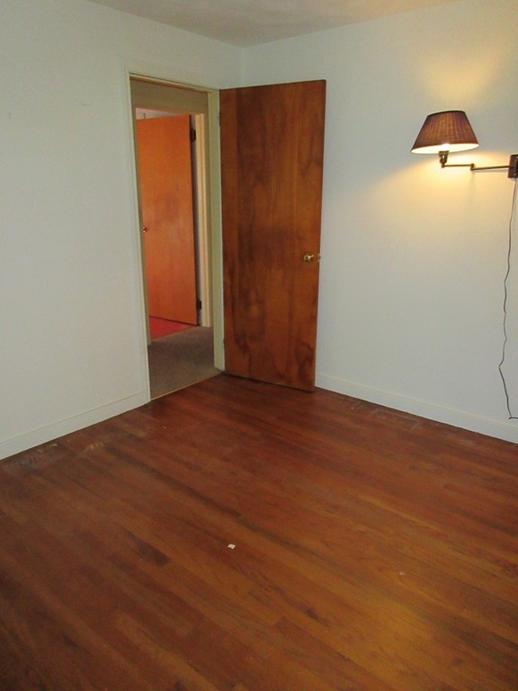 193 Ryan Road Northampton, MA 01062 - Photo 4 of 19 an empty room with wooden floor and cabinet