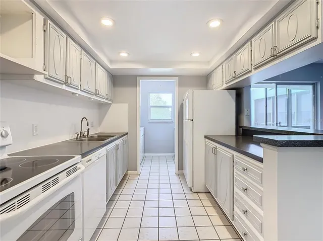 a kitchen with white cabinets and appliances
