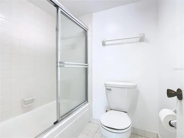 a white toilet sitting next to a bath tub and a shower