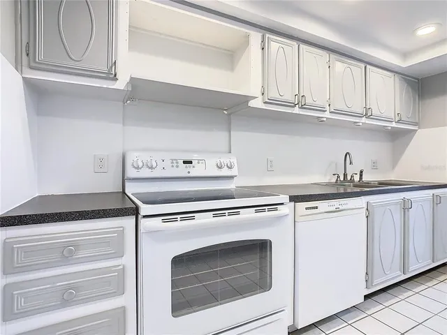 a kitchen with granite countertop white cabinets and white appliances